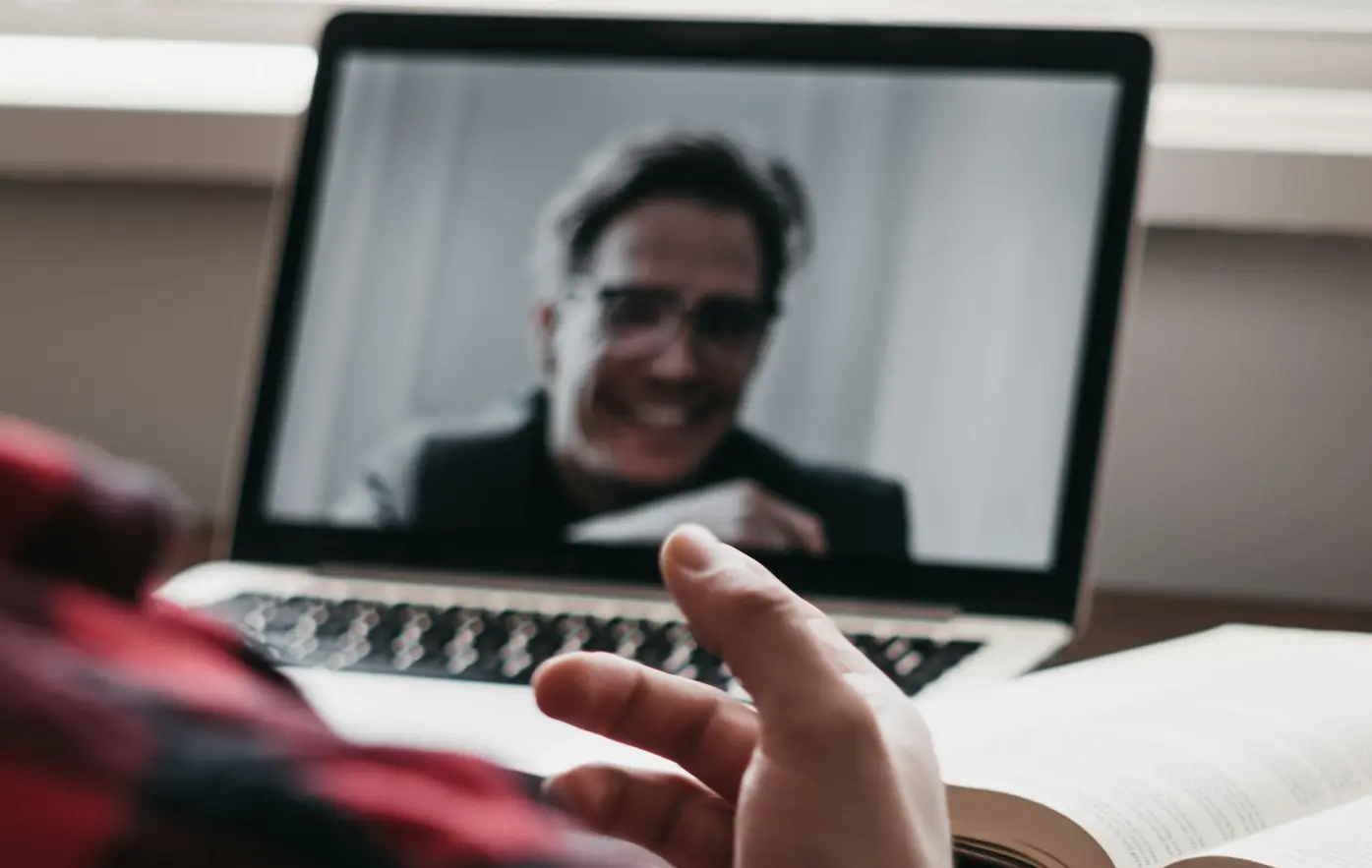 person in red and black plaid long sleeve shirt using black laptop computer